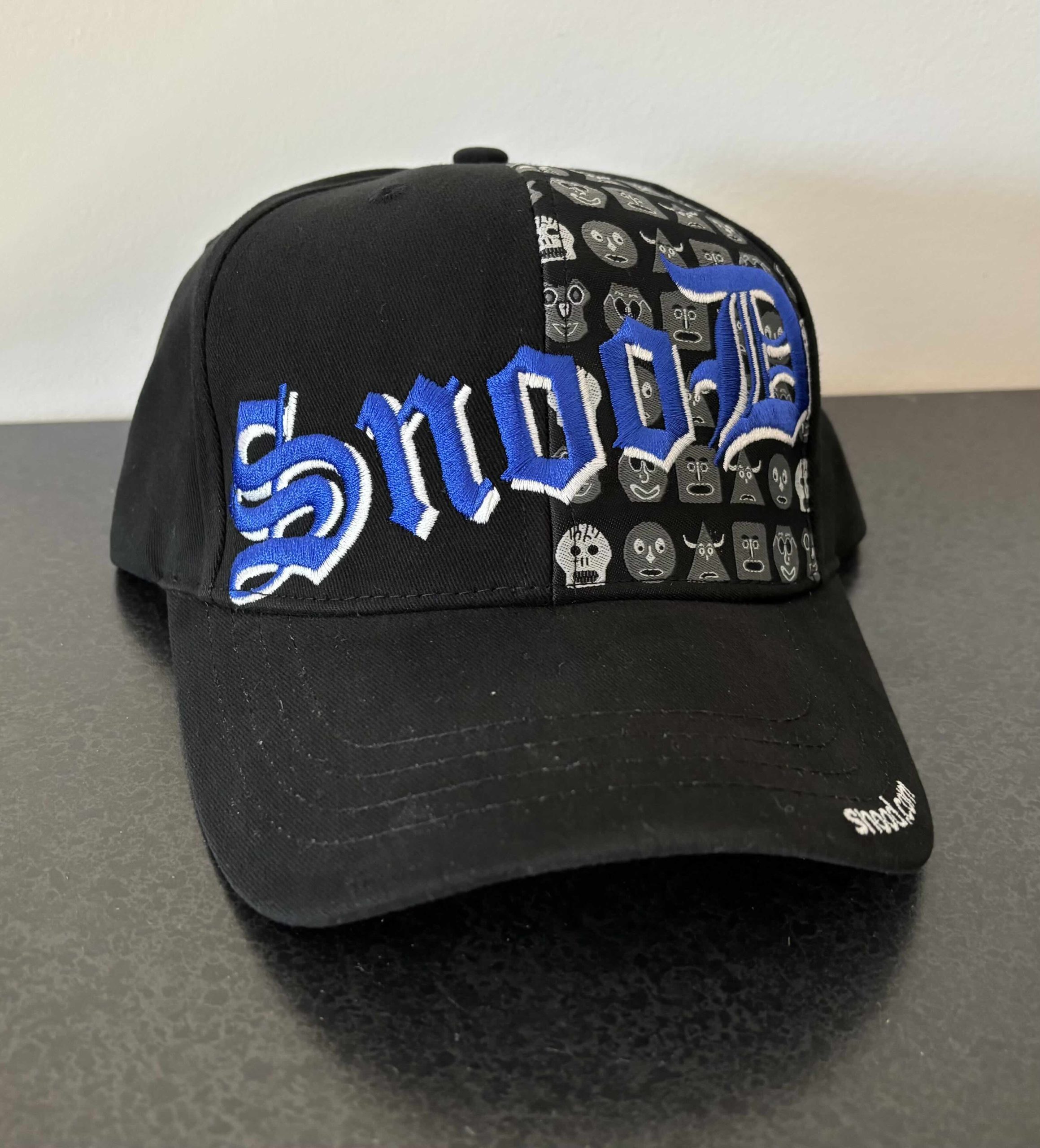Black cap with blue Snood Lettering